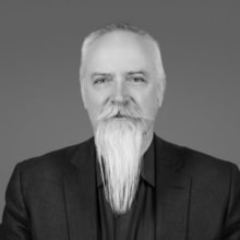 A black and white photo of a man with a long white goatee