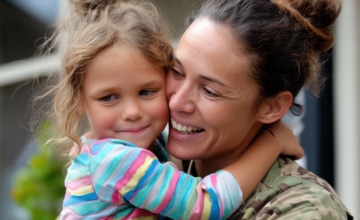 a military mother holds a young girl