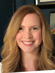 a smiling woman with long red hair