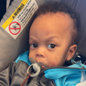 a male baby in a carseat with pacifier