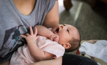 A mother holding an infant.