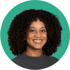 a smiling woman with curly dark hair wearing a black dress shirt