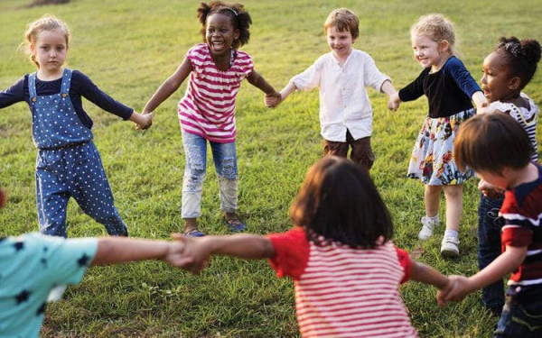 children-holding-hands-in-circle-on-grass